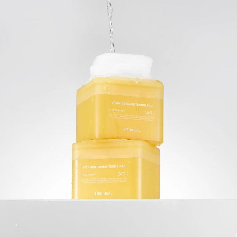Container with 100 white pads soaked in a yellow liquid. This is Mediheal Vitamide Brightening Pads, a facial skincare product for brightening skin.