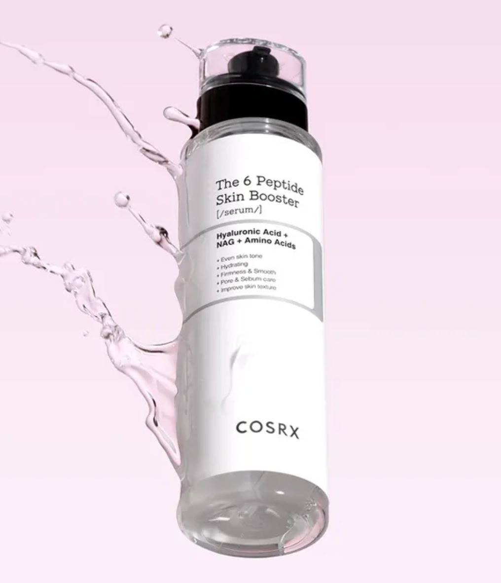 COSRX The 6 Peptide Skin Booster serum in a clear cylindrical bottle with a white label and black pump, shown floating against a soft pink background with water splash graphics.