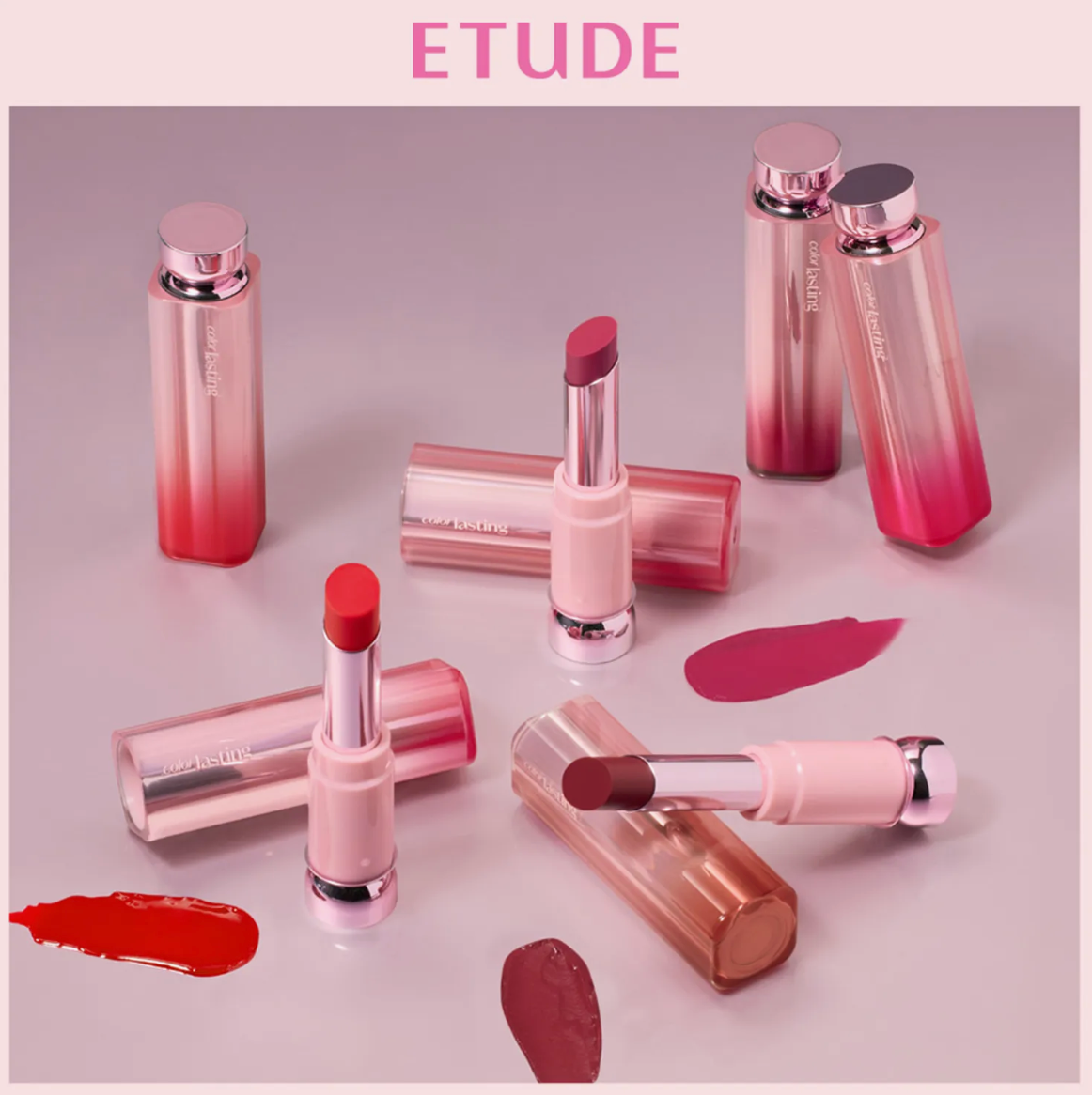 A collection of ETUDE lipstick tubes and open lipsticks arranged on a soft pink studio background, with several lipstick swatches placed in front. The word ETUDE appears at the top.