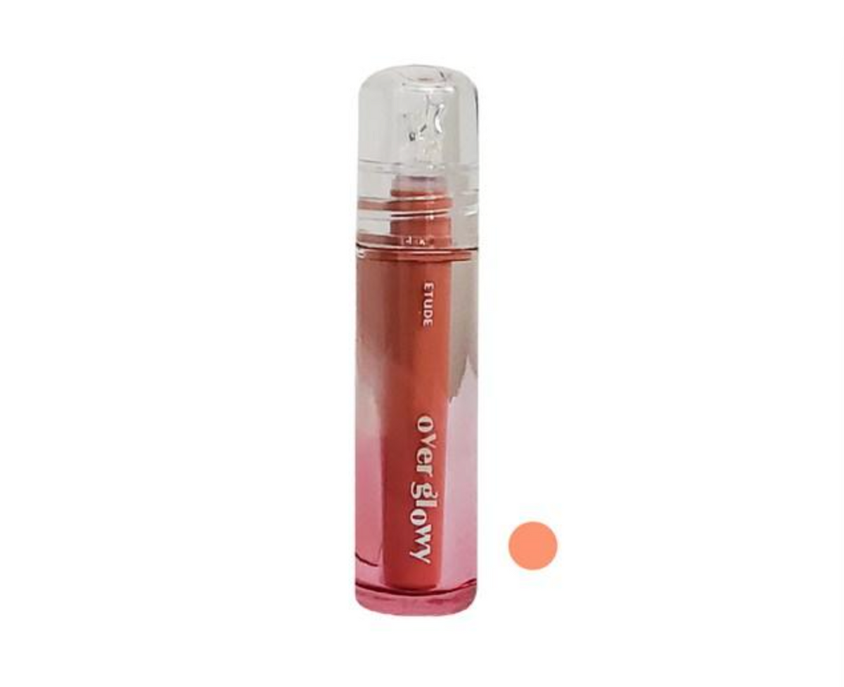 A clear cylindrical cosmetic bottle with a transparent cap, filled with a pink-to-rose gradient liquid. A plain white background with a small peach swatch circle to the right.