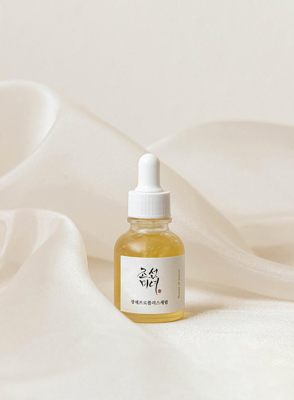 30ml bottle of Beauty of Joseon Glow Serum, a Korean skincare serum with propolis and niacinamide for radiant and balanced skin up against a white flowy backdrop