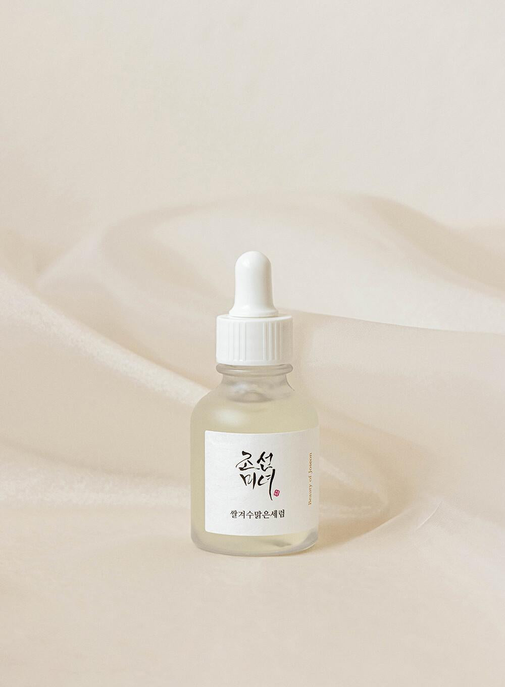 30ml bottle of Beauty of Joseon Glow Deep Serum, a Korean Hanbang (traditional herbal medicine) serum with rice and alpha arbutin for a radiant complexion up against a white flowy backdrop