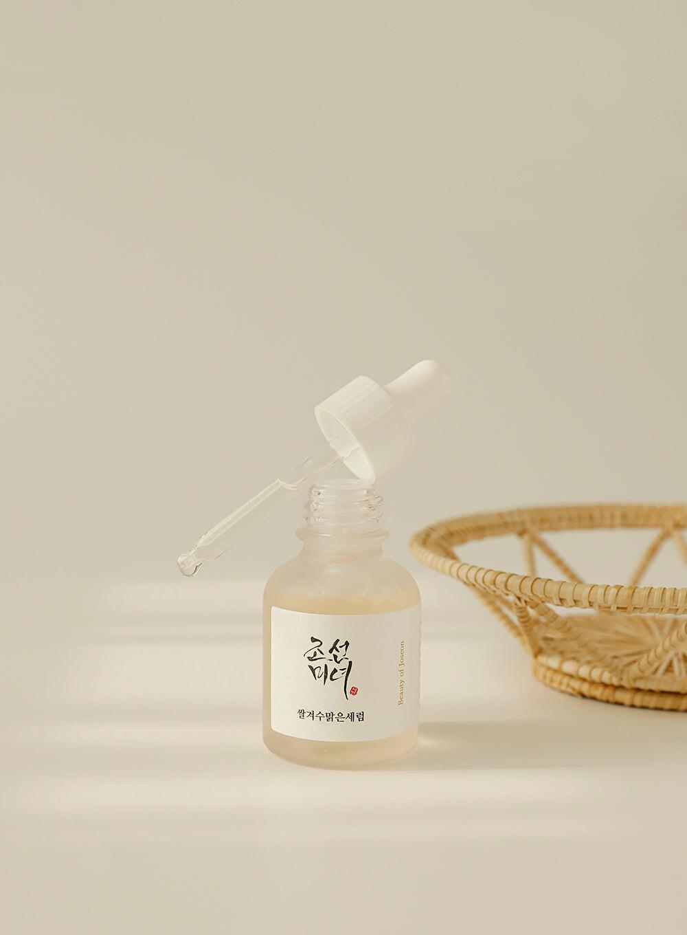 30ml bottle of Beauty of Joseon Glow Deep Serum, a Korean Hanbang (traditional herbal medicine) serum with rice and alpha arbutin for a radiant complexion up against a white flowy backdrop