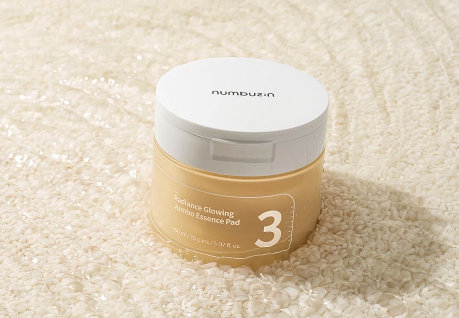 A jar of Numbuzin No. 3 Radiance Glowing Jumbo Essence Pads, containing 70 pre-soaked pads in 150ml of essence for brightening and hydrating skin.