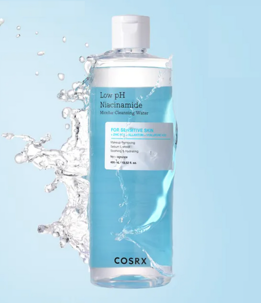 COSRX Low pH Niacinamide Molely Cleansing Water in a clear bottle with a white cap, set against a light blue background with a water splash graphic on the left.