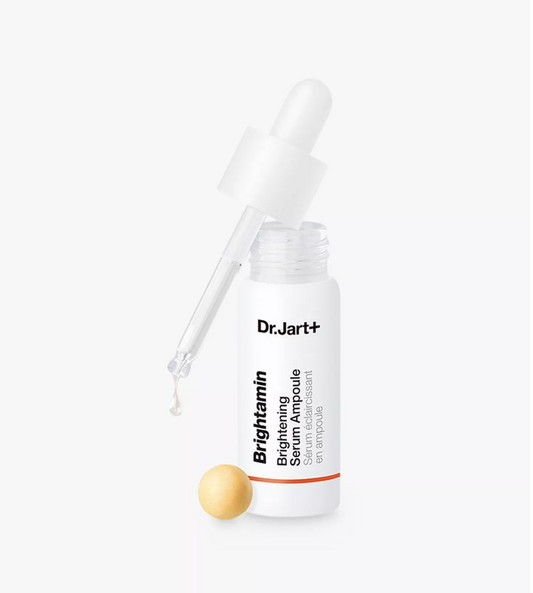 Dr. Jart+ Brightening Serum Ampoule in a white bottle with a glass dropper, shown on a clean white background with a small gold ampoule ball beside it.
