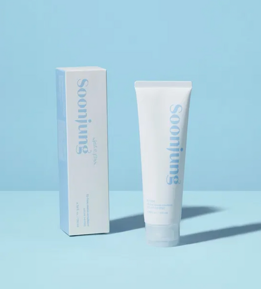 A white cosmetic tube and matching white box with light blue text, photographed on a light blue studio background. The tube is labeled Soonjung.