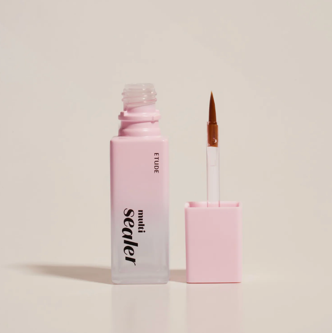 A bottle of ETUDE Sealer liquid with a pink-to-clear gradient and a separate applicator brush with a pink cap, set against a solid light beige background.