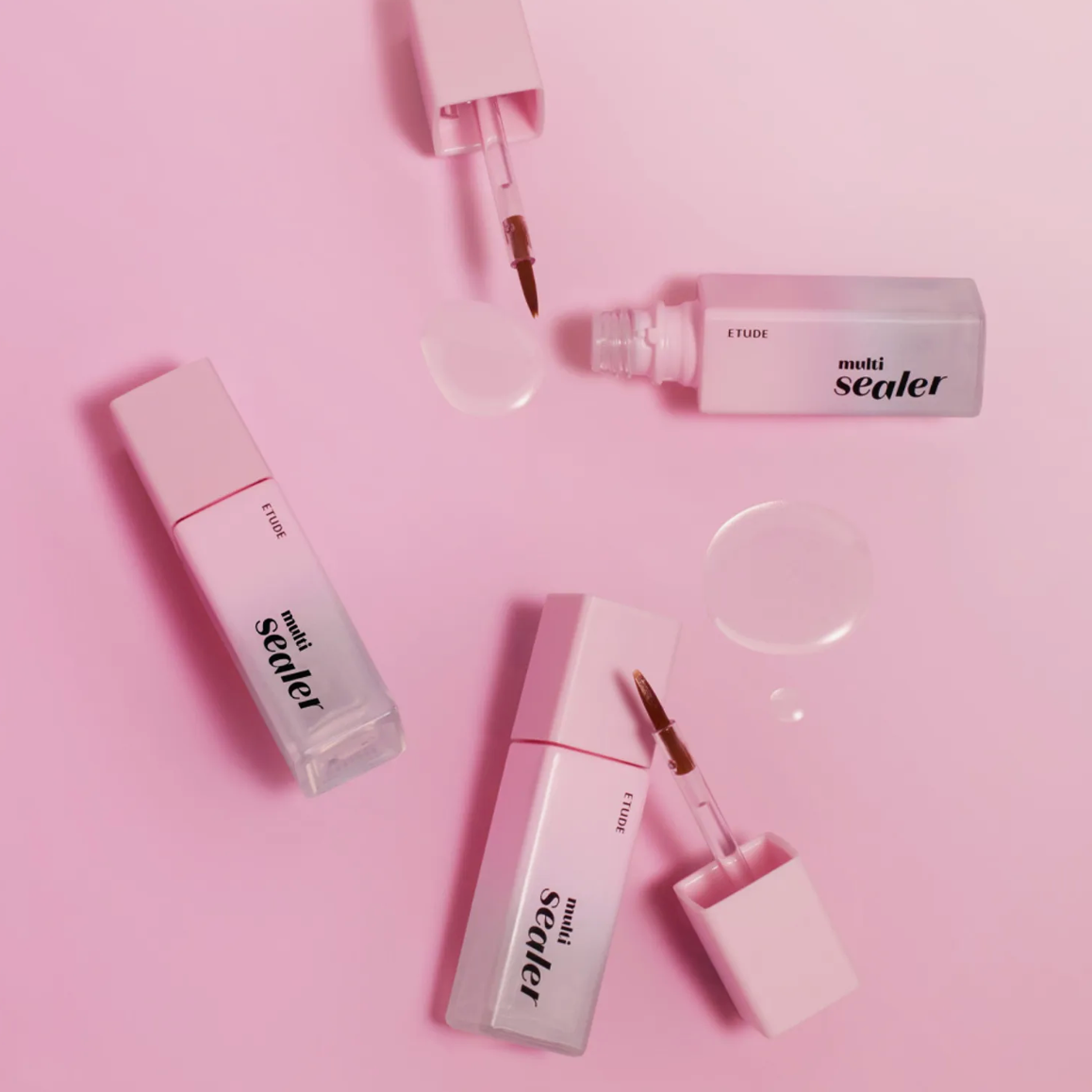 Three pink cosmetic tubes and applicators arranged on a solid pink background. The product branding reads 'multi sealer' and 'Etude'.