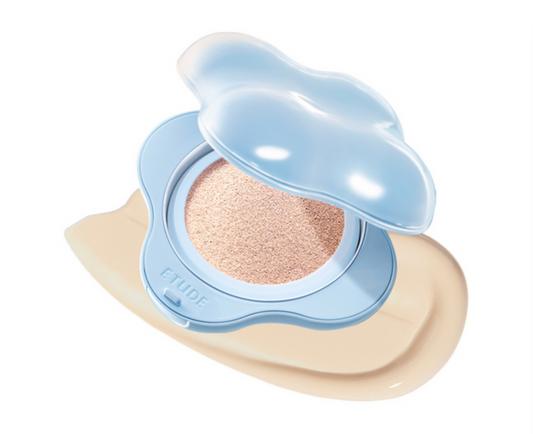 ETUDE House liquid foundation cushion in a light blue cloud-shaped compact, shown open with the pressed powder visible and a smear of the beige foundation underneath on a white background.