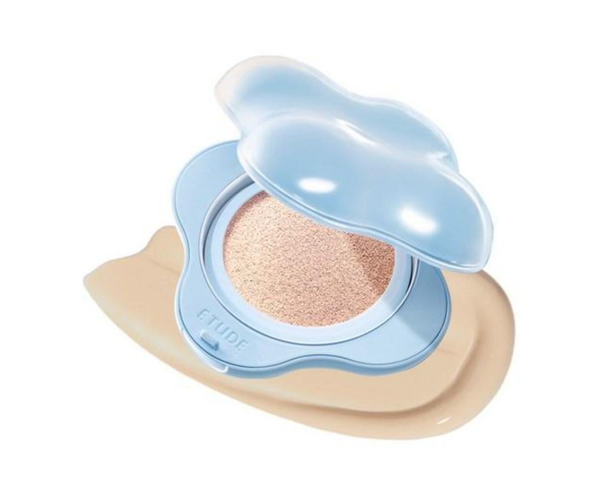 An open FLUIDE cushion foundation compact with a light blue cloud-shaped case and a beige foundation pan, set against a clean white background.