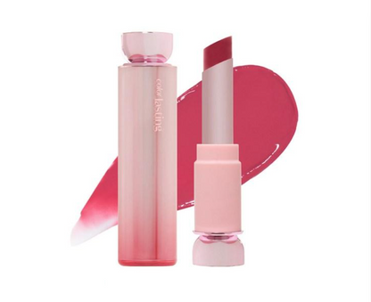 A pink cosmetic lipstick shown with its cap on and cap off, alongside a pink product smear on a white background. The brand name 'color by Leslie' is visible on the tube.