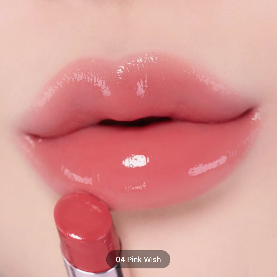Close-up of glossy pink lips wearing a lip product, with the lipstick bullet held below the lips. Text overlay reads '04 Pink Wish'.
