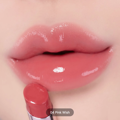 Close-up of glossy pink lips wearing a lip product, with the lipstick bullet held below the lips. Text overlay reads '04 Pink Wish'.