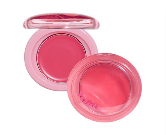 Two round pink makeup compacts on a white background, one open to show a rosy pink pressed powder and the other showing a pink sponge inside a clear lid.