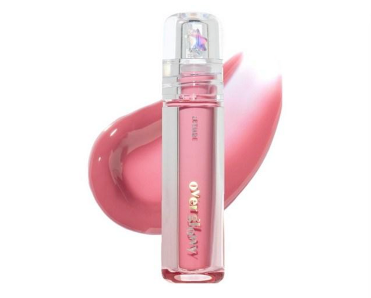 A clear cylindrical bottle of lip gloss with pink liquid inside, shown in front of a glossy pink product smear on a white background.