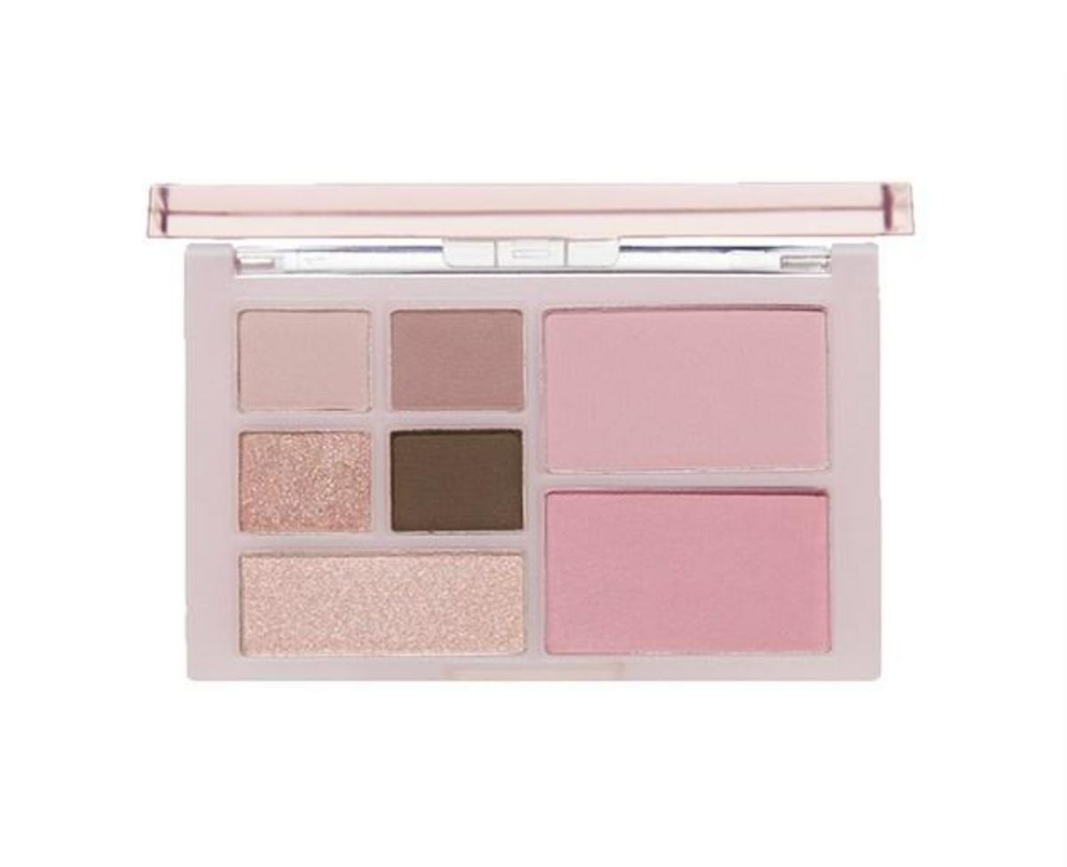 A makeup palette with a pale pink case, featuring neutral and pink shades including two shimmering eyeshadows, a deep brown shadow, and two large pink blush or highlighter pans, shown open on a white background.