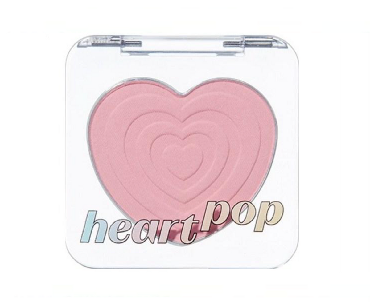 A heart-shaped blush compact with a clear plastic case and the words 'heart pop' printed on the front, set against a plain white background.