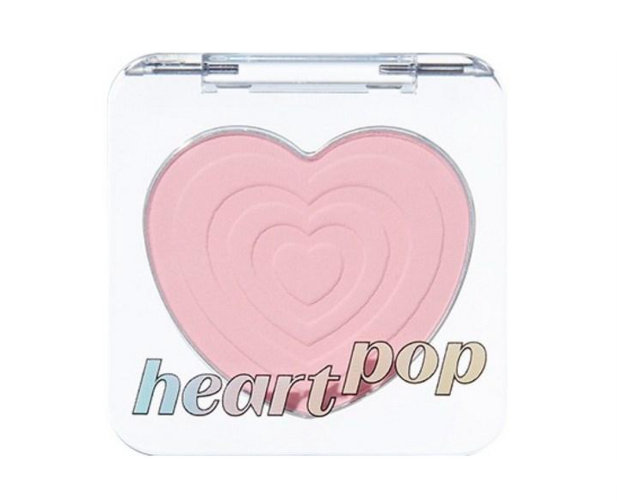 A heart-shaped blush compact with a light pink pressed powder and a clear plastic case, featuring the text 'heart pop' printed on the front.