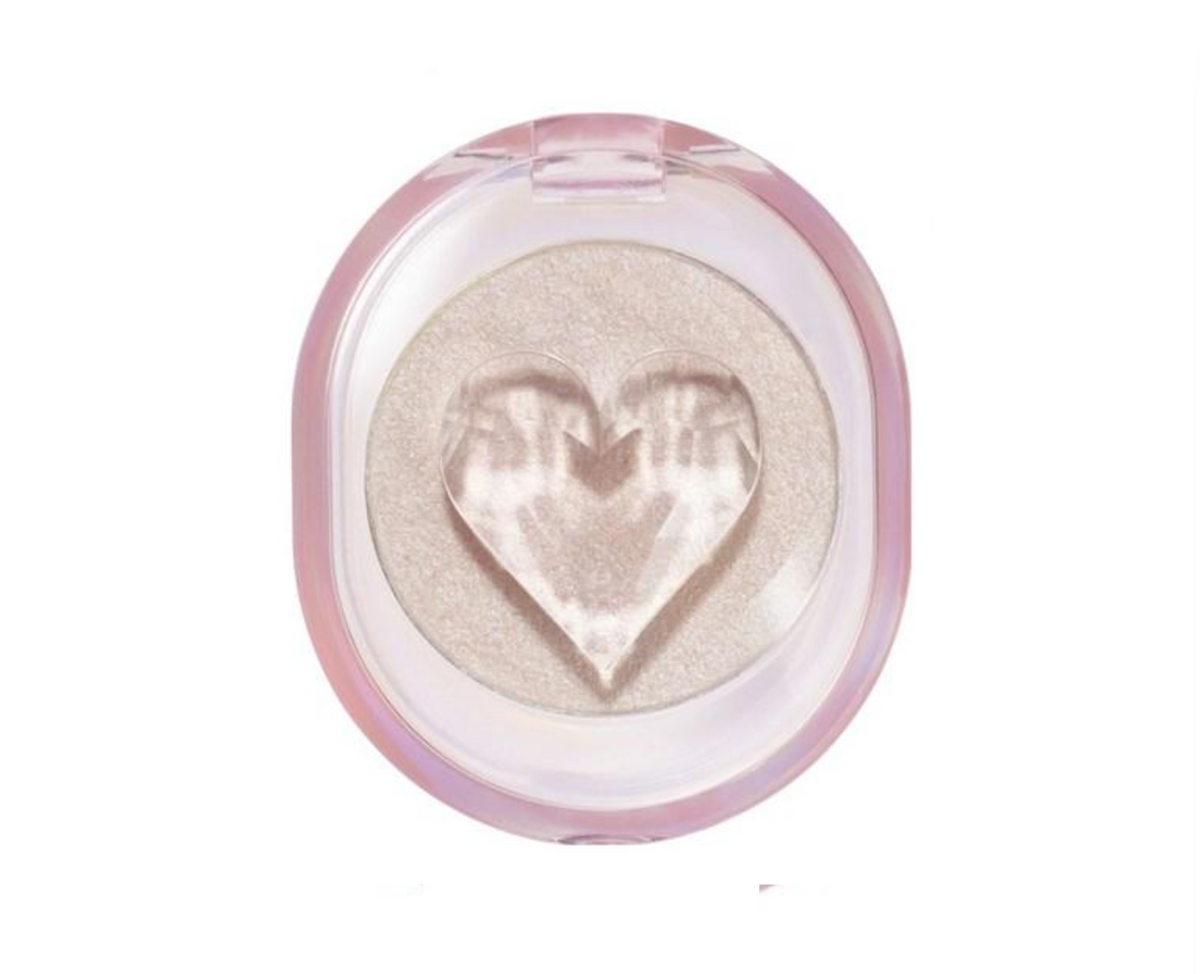 A single-pan eyeshadow compact with a heart-shaped embossed design in the center of the pressed powder, housed in a translucent pink case on a white background.