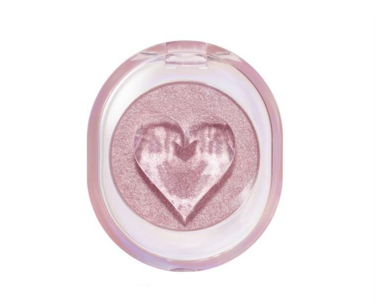 A single-pan eyeshadow compact with a heart-shaped embossed detail in the center of the shimmering pink shadow, set in a translucent pink case against a plain white background.
