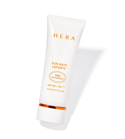 A white squeeze tube of HERA Sun Mate Leports sunscreen with gold text and a gold accent band near the cap, shown on a clean white background with a soft shadow.