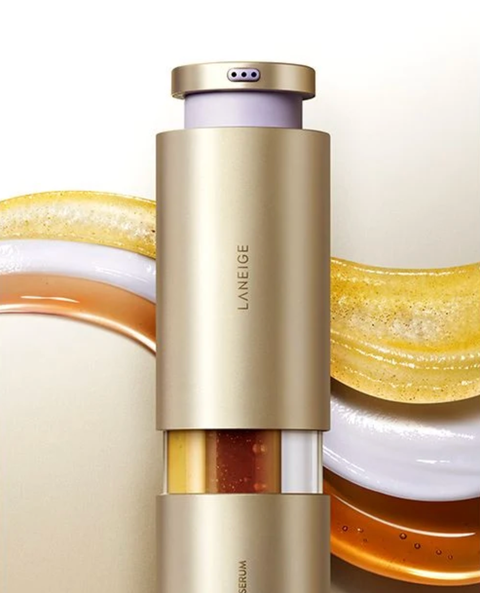 LANEIGE Serum bottle in a metallic champagne gold finish, shown vertically with decorative golden and white curved elements in the background.