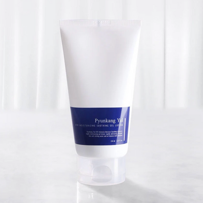 A white squeeze tube with a dark blue label band, set against a bright, softly lit white background.