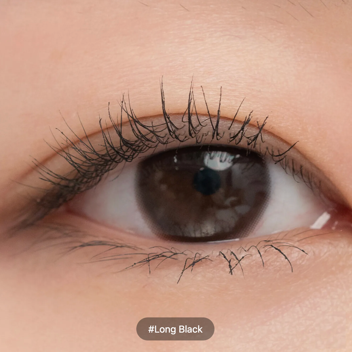 Close-up of a human eye with long, curled black eyelashes and a brown iris, with a label reading '#Long Black' at the bottom.
