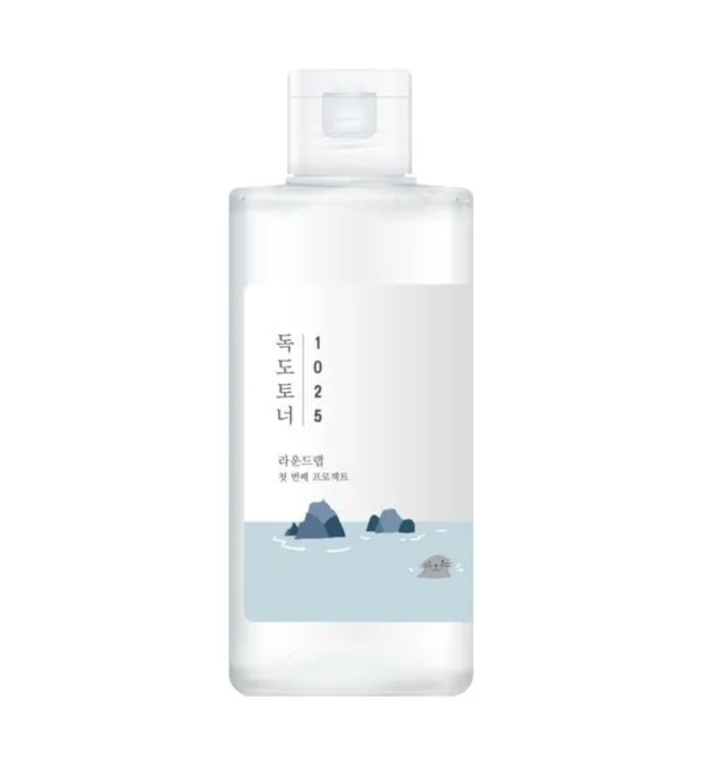 A clear plastic bottle with a white cap and a minimalist label featuring a light blue water design with dark blue rocks.