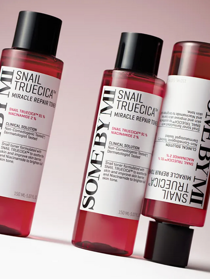 Three red cosmetic bottles of SomeByJii Snail TruCica Miracle Repair Toner arranged diagonally on a white surface with a soft pink background.