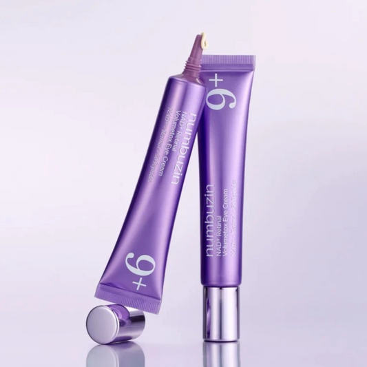 Two purple tubes of numbuzia +9 Numb Relief Pain Relieving Cream, one standing upright and the other lying on its side with the cap removed, on a light gray reflective background.